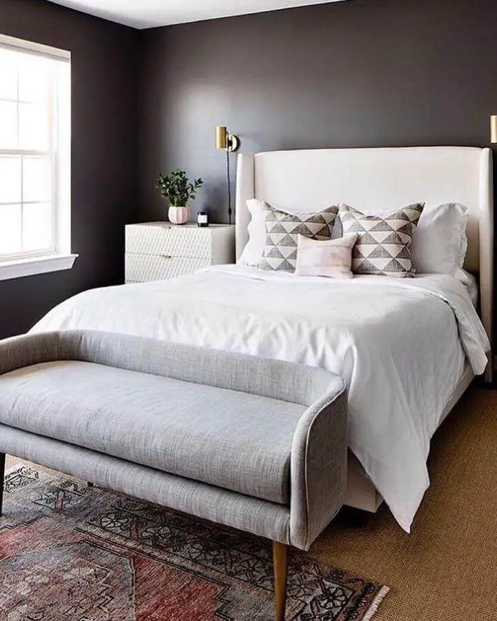 Charcoal bedroom from @theeditlifestyle.ca with white bedding and upholstered bench creating sophisticated contrast.