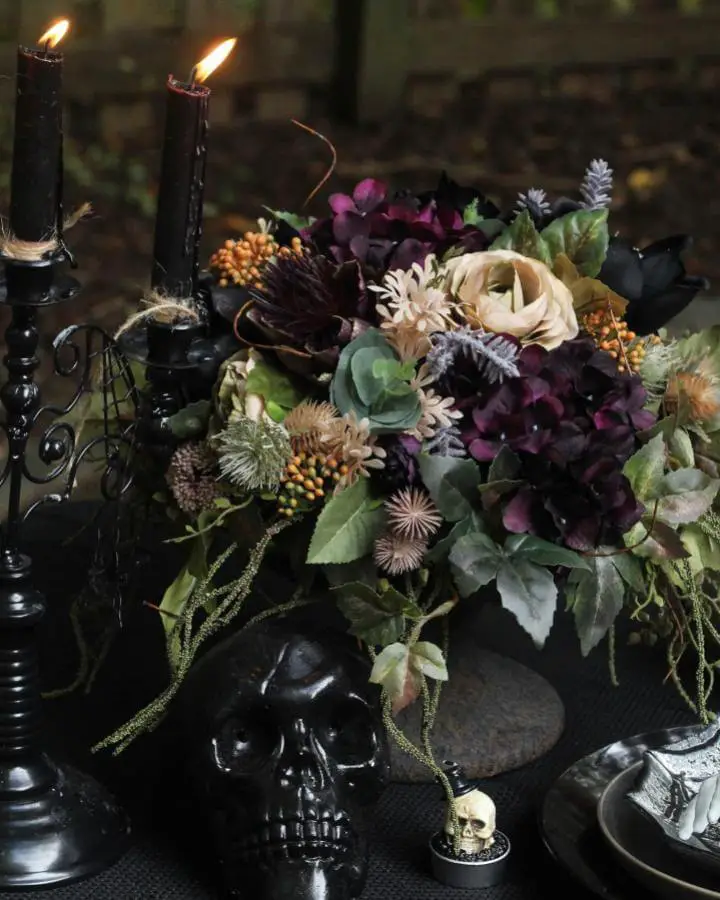Gothic floral arrangement with spiky seed pods from @rea_stylenc showing creative halloween centerpiece ideas with purple blooms.