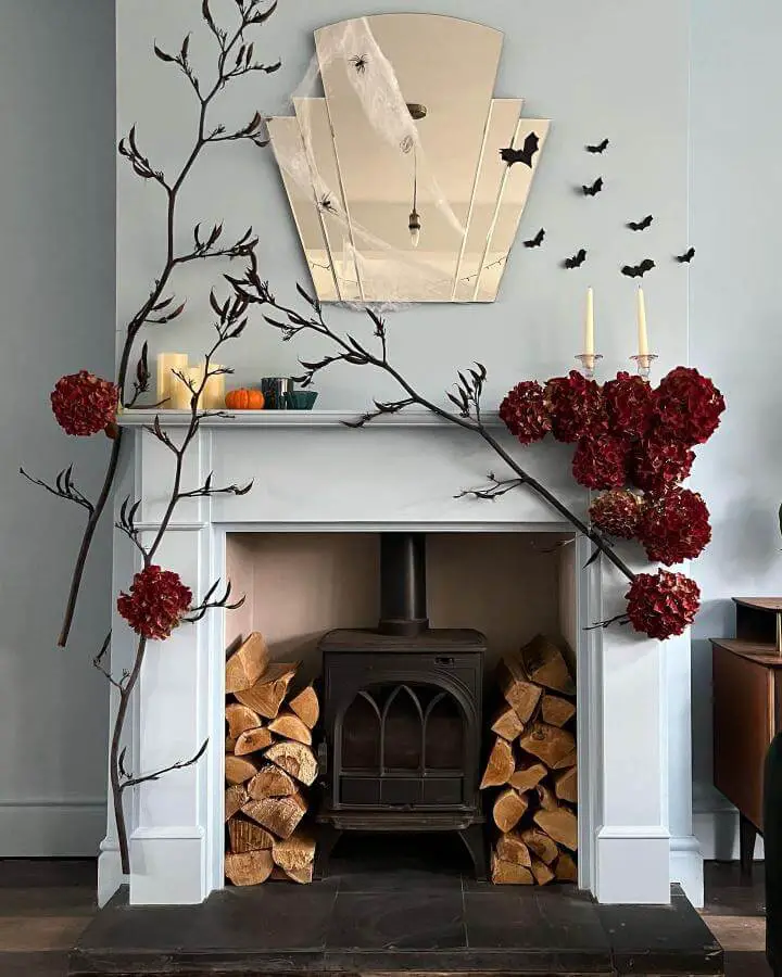 Burgundy hydrangea branches from @my_liverpool_abode. Black paper bats flutter above white fireplace mantel with candles.