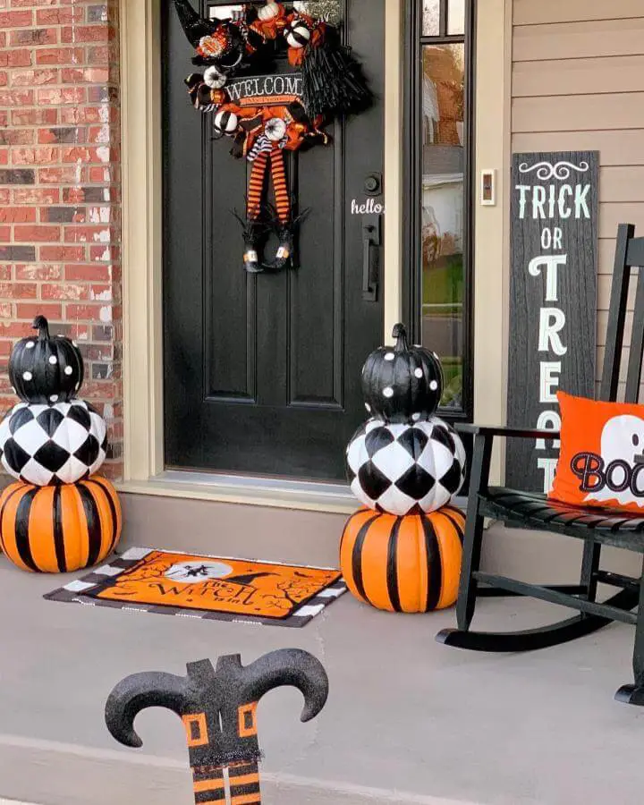 Stacked black and orange pumpkin topiaries flanking front door for halloween porch decor from @decor_ate_with_sharon.