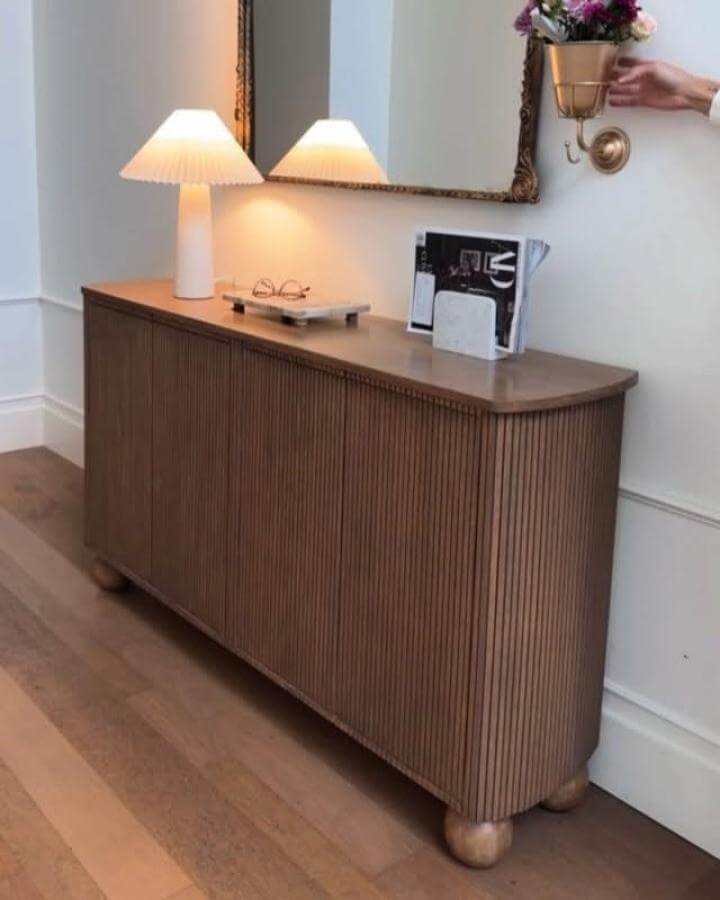 walnut slatted wood sideboard in entryway from @abby_roadhome with rounded edges and soft lighting