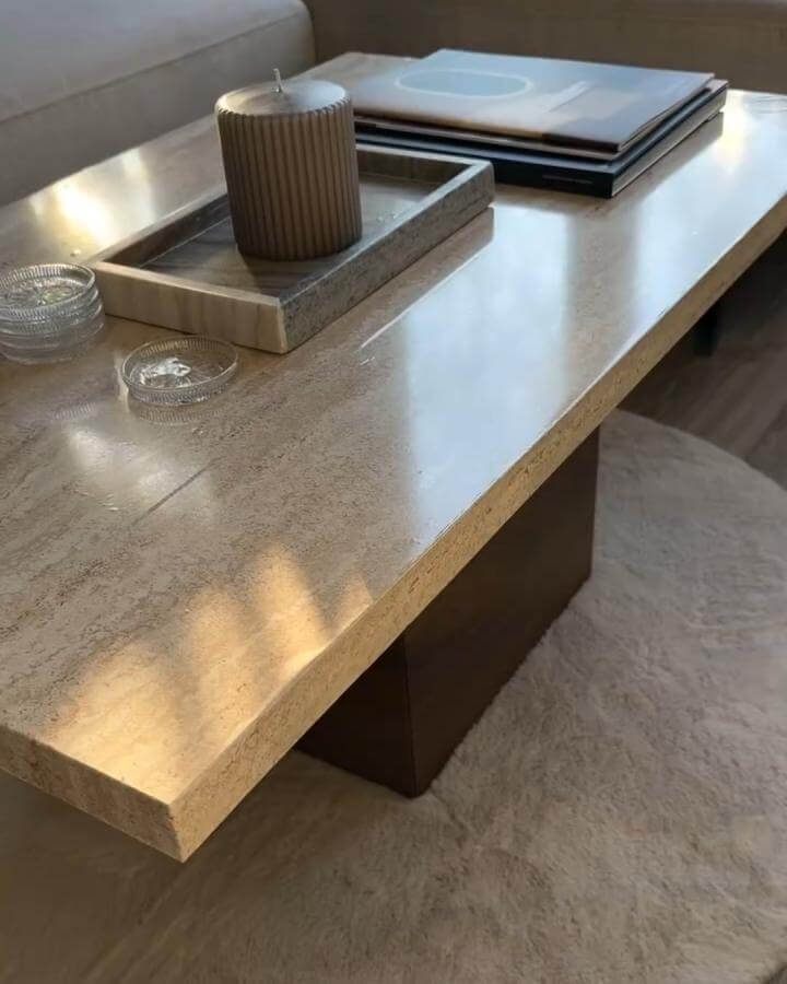 beige stone coffee table with dark wooden base from @lisiaaronson. Minimalist Japandi style living room furniture.