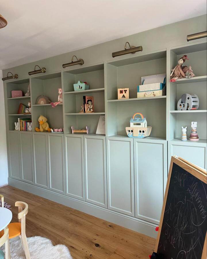 sage green panel detailed Billy bookcases with brass lights in children's room by @nadjasnest elegant functional storage unit
