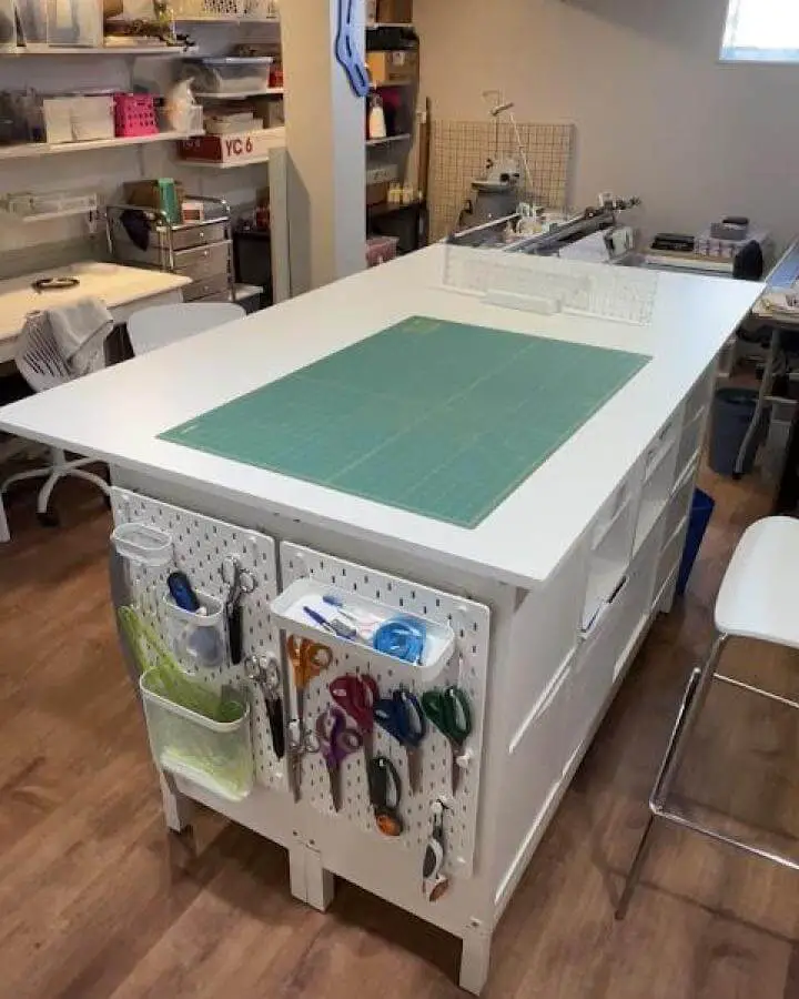 White pegboard storage and large cutting mat on an Ikea craft table from Dressmaking Debacles showing organized tools and workspace.