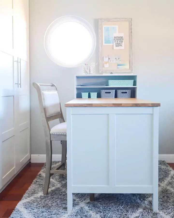 White craft island with wood top and pastel storage bins in compact space from @katy_ashadeofteal ikea craft table hacks bright and cozy room setup