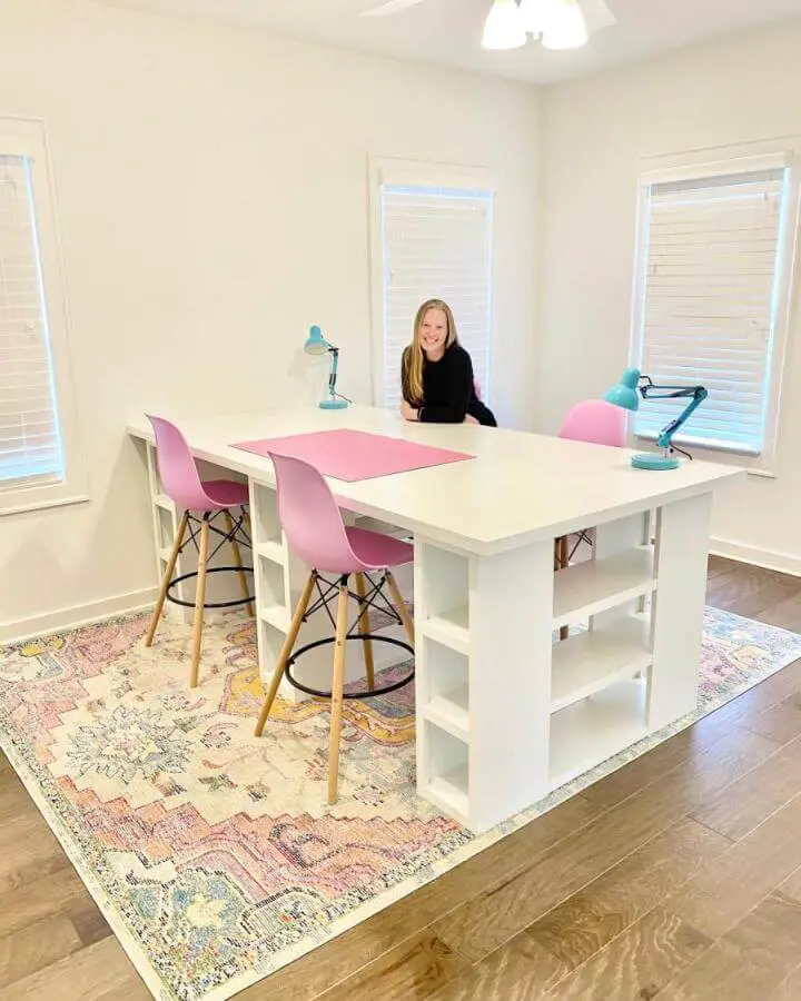White craft table with integrated shelving and pastel chairs in bright room from Elizabeth Wade Studio perfect example of ikea craft table hacks.