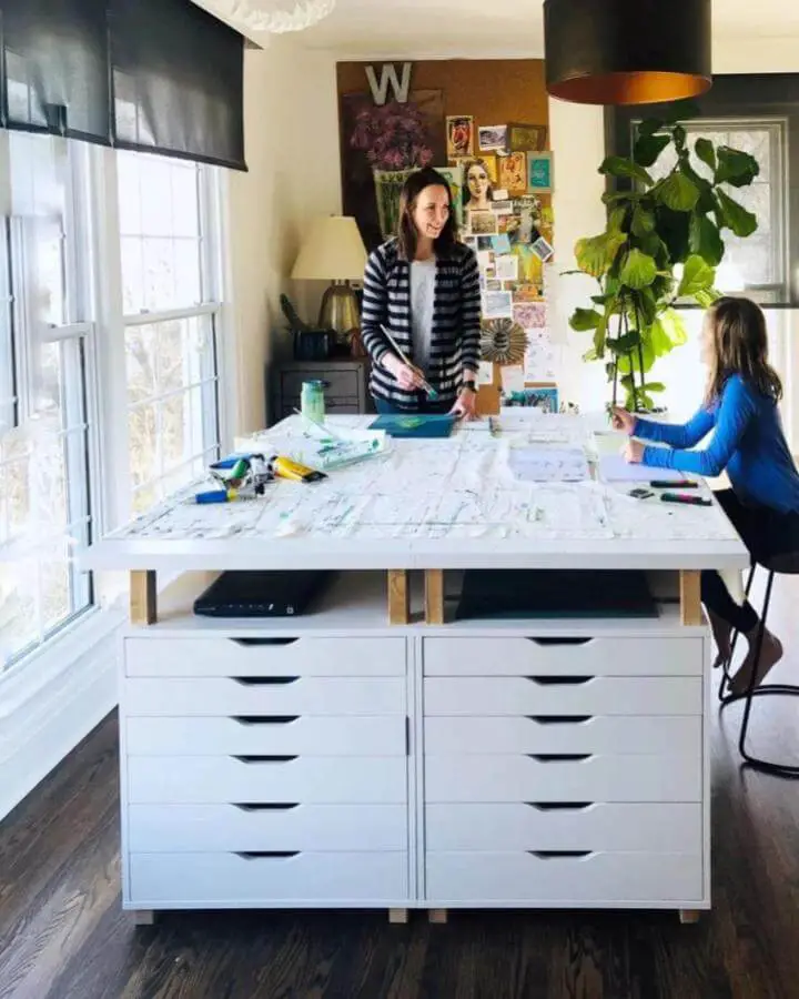 White drawer storage craft table from Home with Andrea Sims with wooden risers and bright natural light ikea craft table hacks