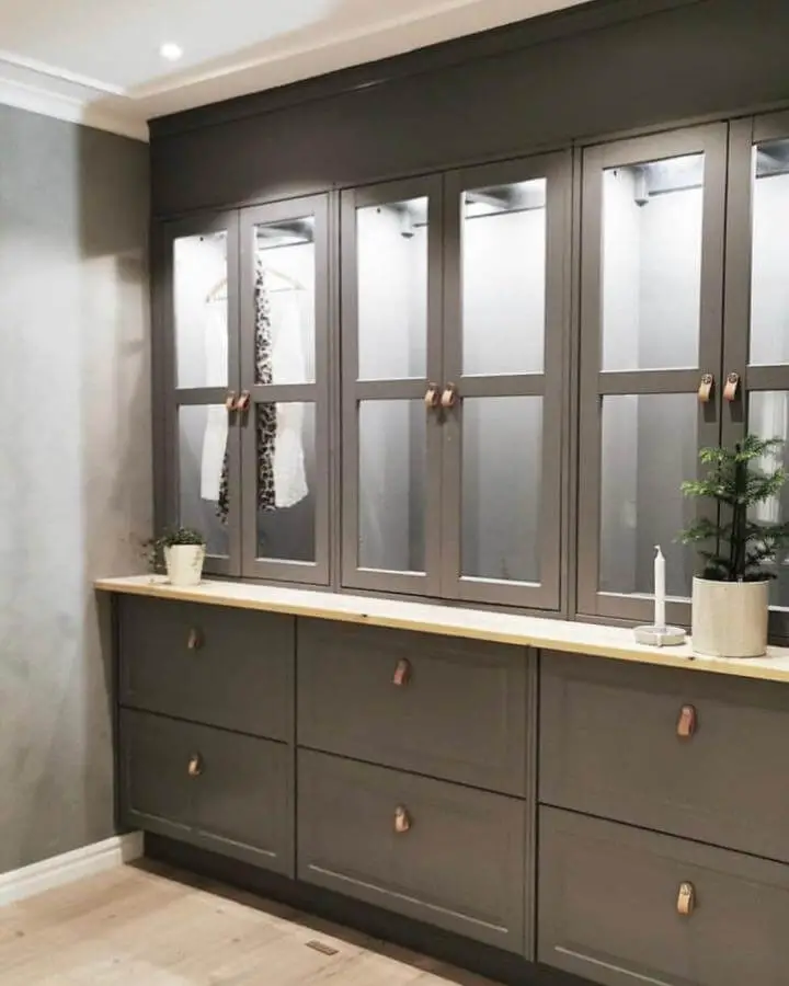 Charcoal grey cabinet unit from @renoveringsdamm with copper leather pulls and glass doors.