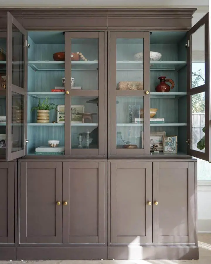 Gray cabinet with duck egg blue beadboard interior from @rebeccaandgenevieve. Glass doors reveal textured backing.