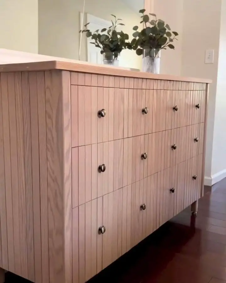 Light natural wood dresser with vertical slats and metal knobs from @thecustombuildher ikea hemnes hacks.