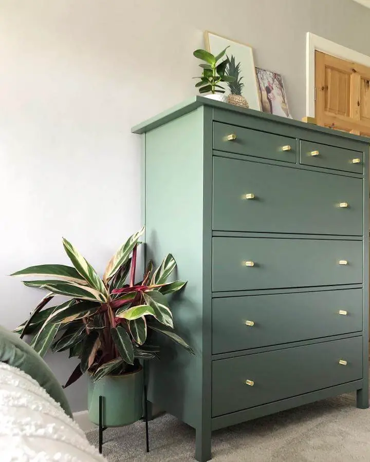 Green matte painted Ikea Hemnes dresser with gold knobs and matching plant pot from @singinginthereno in a cozy bedroom corner.