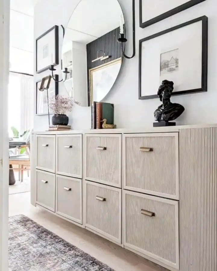 Off-white slatted cabinet doors with brass handles in a bright hallway from @collettes_home showing ikea hemnes hacks.