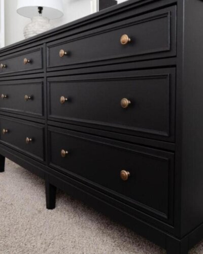 Black Ikea Koppang hacks dresser with brass knobs and molding detail from Jessica Belteau, sleek and modern style.