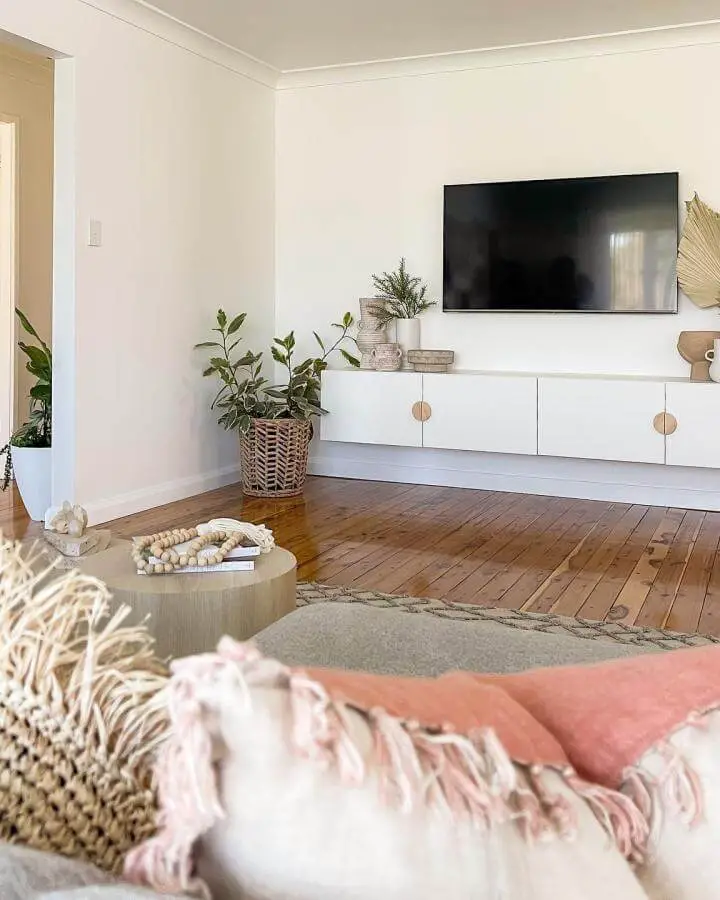 White floating media cabinet with wood handles and woven basket in a bright living room from @katrinas_instagram showing ikea media center hacks & ideas.