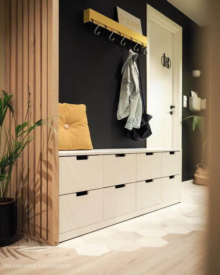 white ikea nordli hacks storage bench with black cut-out handles in modern entryway from @karroogcarry minimalist design with yellow accents