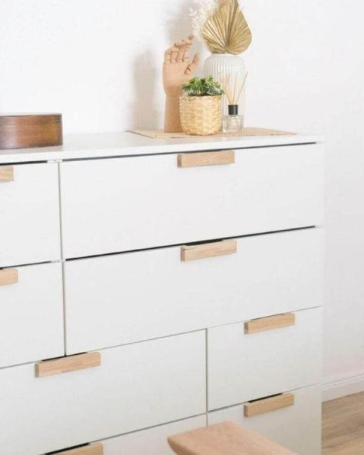White Nordli dresser with wooden handmade handles from @fraeulein.diy showing a clean minimalist Ikea nordli hacks style.