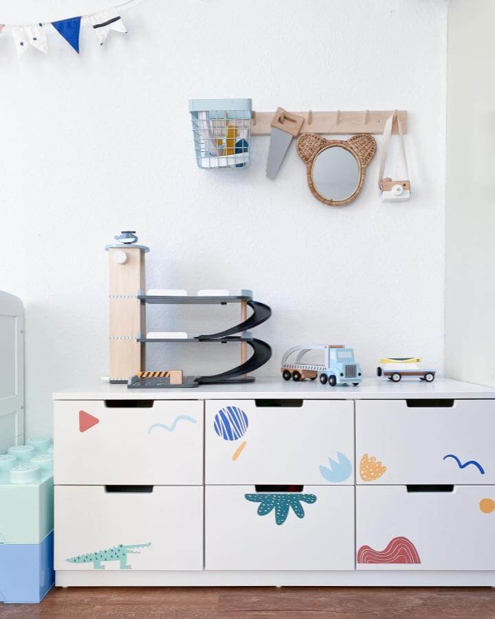 White Ikea Nordli dresser with colorful playful decals in a child’s room by @pimpadstudios neat toy storage and organization.