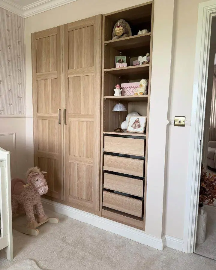 Light oak built-in wardrobe and drawers from @homebyrosie with ikea pax hacks in a softly furnished nursery room.