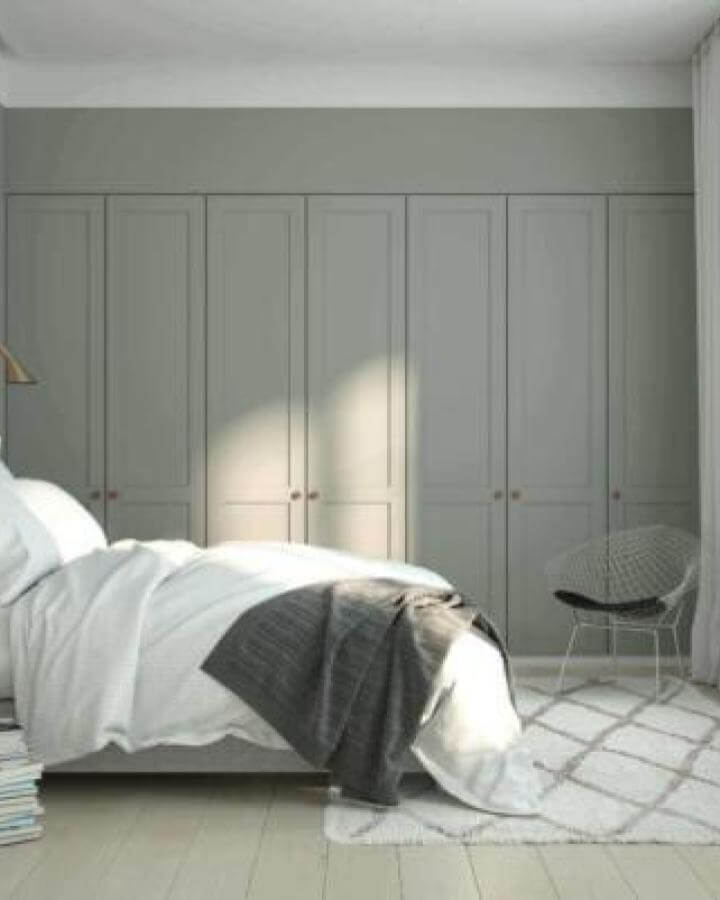 Soft green panelled wardrobe doors in a bedroom by Helsingo with ikea pax hacks style