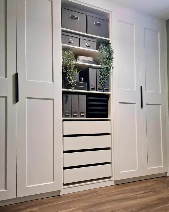 White Ikea Pax wardrobe with integrated open shelves and black storage bins from @gemswhitworthhome. Organized and modern ikea pax hacks.