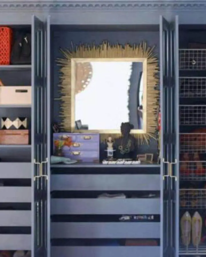 Dark navy vanity nook inside Ikea Pax closet from Domino with golden sunburst mirror and lilac organizer chest.