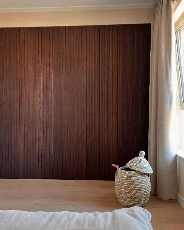 Dark stained wood paneled Ikea Pax wardrobe from @huisjeinhetpark with cozy natural light and textured basket accessory.