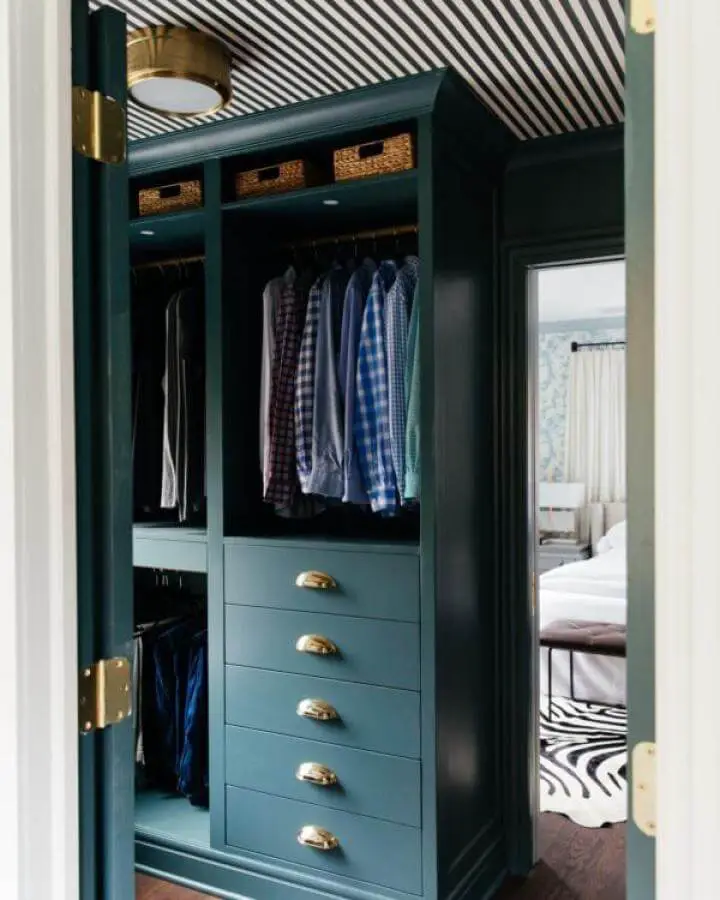 Deep green painted Ikea Pax closet with brass drawer handles and wicker baskets from Erin Kestenbaum. Stylish and organized space.