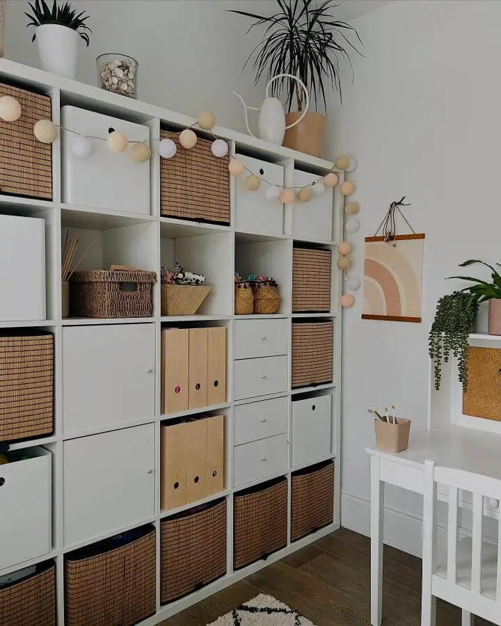 Woven basket and white cube shelving playroom storage from @homebird_mrsmac with soft string lights and natural decor accents.