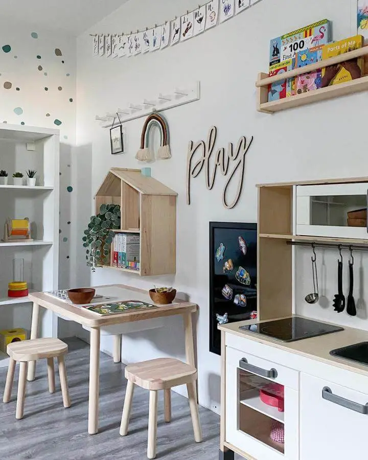Natural pine wood playroom furniture and wall storage from @playroominspo with kids table, stools, and house-shaped shelf.