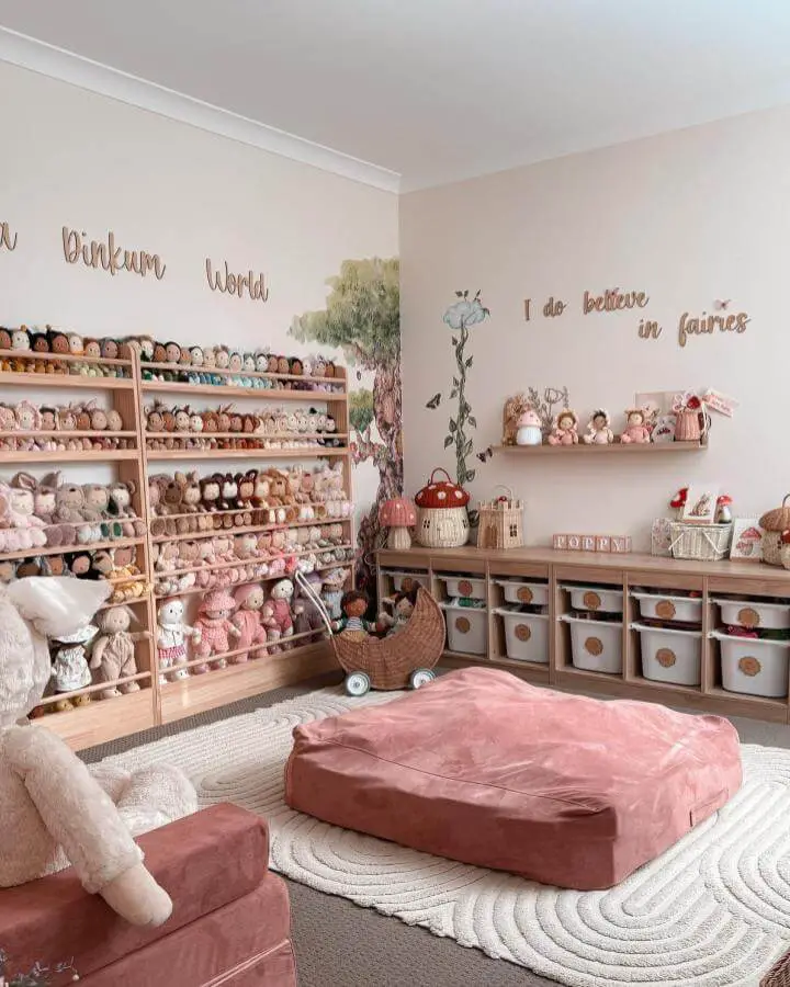 Natural wood shelves and baskets with soft pink velvet seating in a playroom from @poppymae___. Ikea playroom storage hacks & ideas with plush toys and neat containers.