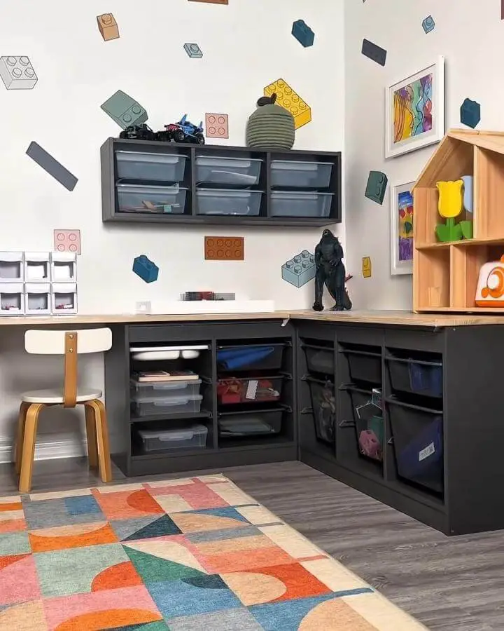 Black shelving unit with clear bins and playful block wall decals in a kid's playroom from @playroominspo showcasing ikea playroom storage hacks & ideas.
