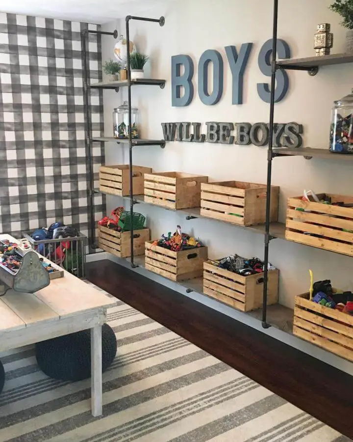 wooden crate storage with industrial pipe shelving in a playroom from @mbhomedesigners filled with toys ikea playroom storage hacks & ideas