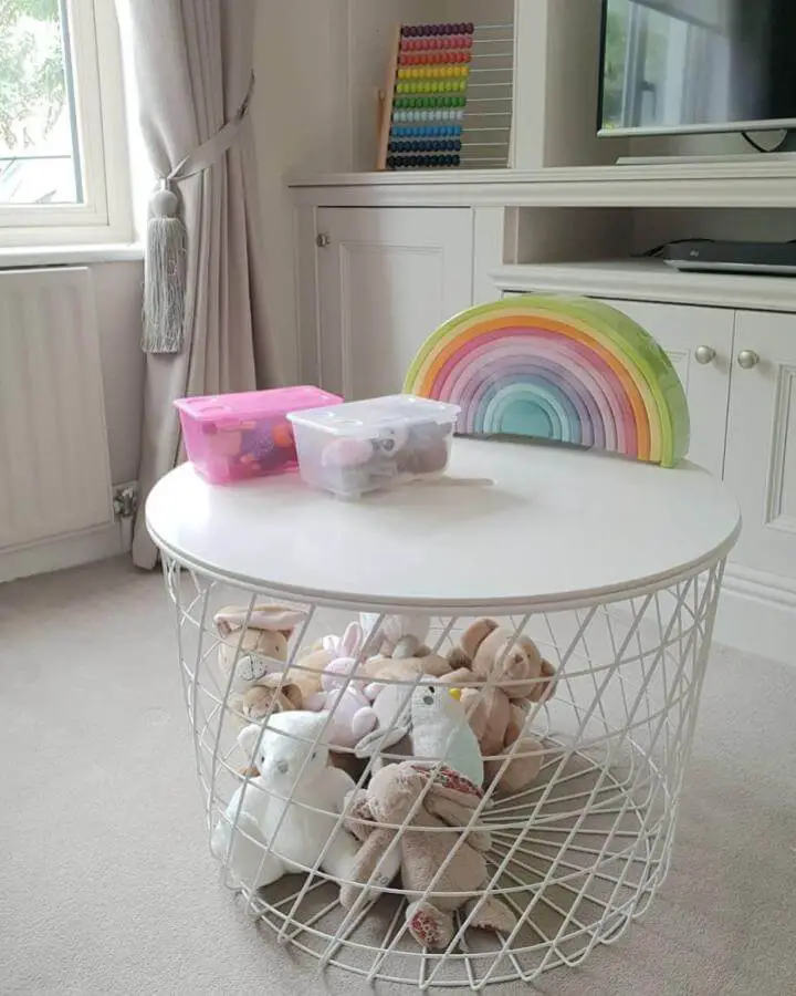 white wire basket table from @for.the.love.of.greige holding stuffed animals with pastel rainbow toy in ikea playroom storage hacks & ideas