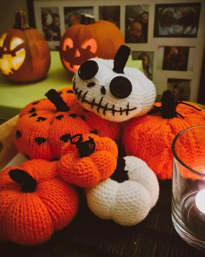 Crocheted Halloween decoration from @jolitm featuring orange pumpkin body with white skeletal head and black details.