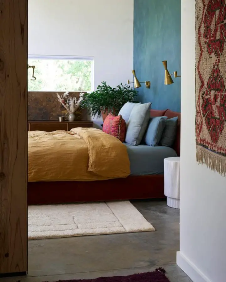 Vibrant teal accent wall bedroom from @viajeradesign. Mustard bedding and burgundy frame complete the rich color palette.