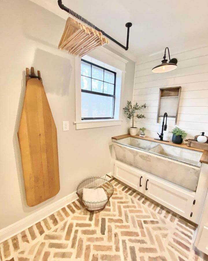 Concrete farmhouse style sink with wood countertop and vintage washboard from @yourlocalrealtorkim in bright cozy laundry room.