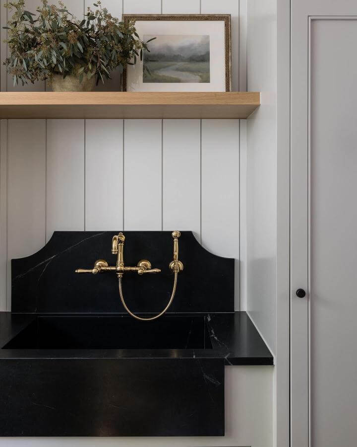 Black stone laundry basin with brass faucet and white shiplap walls by @puresaltinteriors. Elegant, modern, vintage blend.