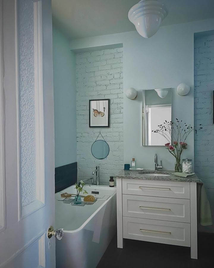 light blue bathroom ideas featuring painted brick accent walls and white vanity from @jsbeauchampdesign soft natural lighting and calming vibe