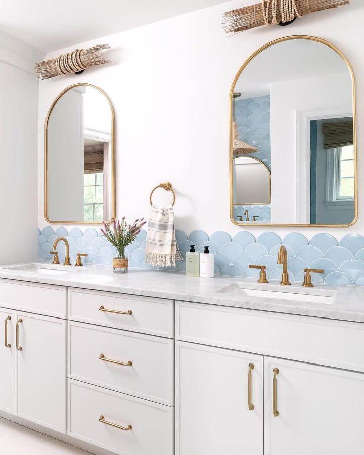 Light blue fish scale tile backsplash with gold fixtures in bathroom from @rudloffcb bright modern design
