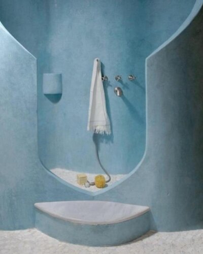 Light blue bathroom ideas with sculptural curved walls and pebble textured floor from @chiaracalvidorizza creating calm modern retreat.