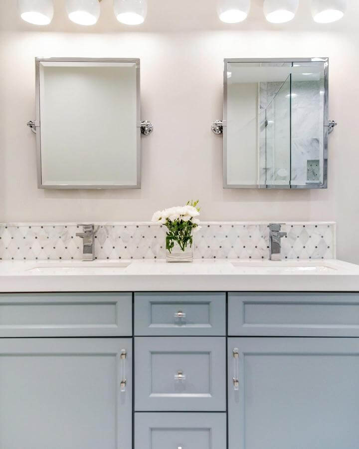 Light blue shaker cabinets bathroom vanity with quartz countertop and marble backsplash from @pamelasandalldesign creating light blue bathroom ideas