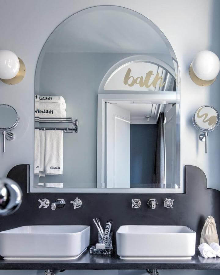 Light blue bathroom ideas with curved mirror, black countertop, and chrome fixtures from @karel_balas creating serene modern style.