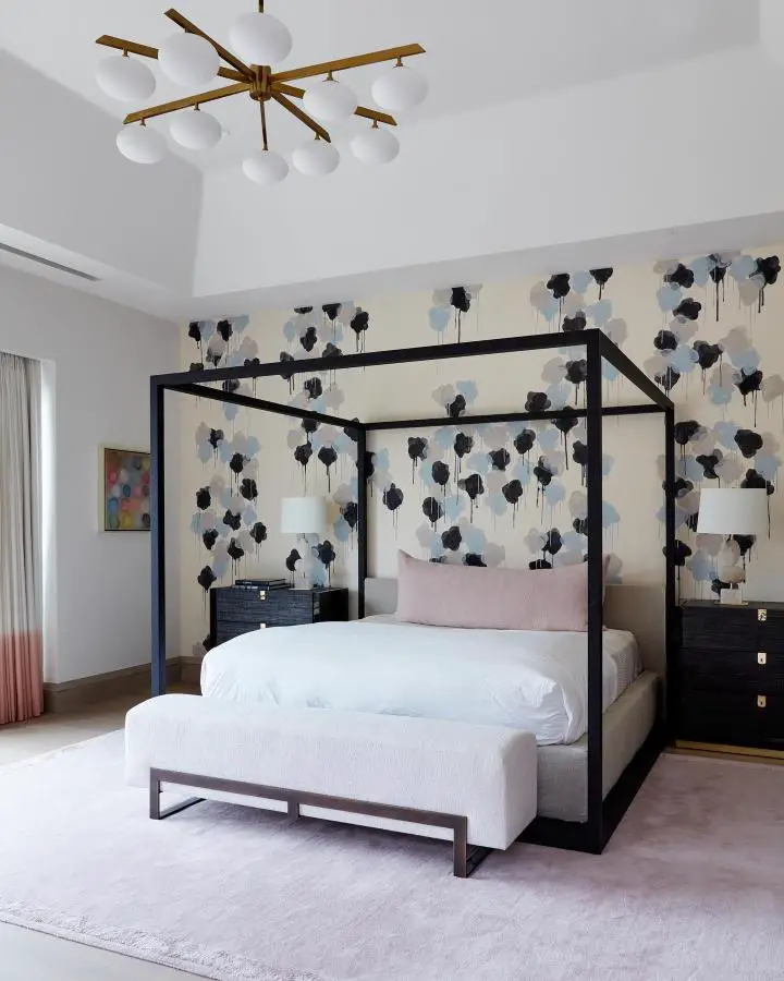 Floral wallpaper bedroom from @jenniferwelchdesigns. Black four-poster bed with navy and blush botanical wall design.