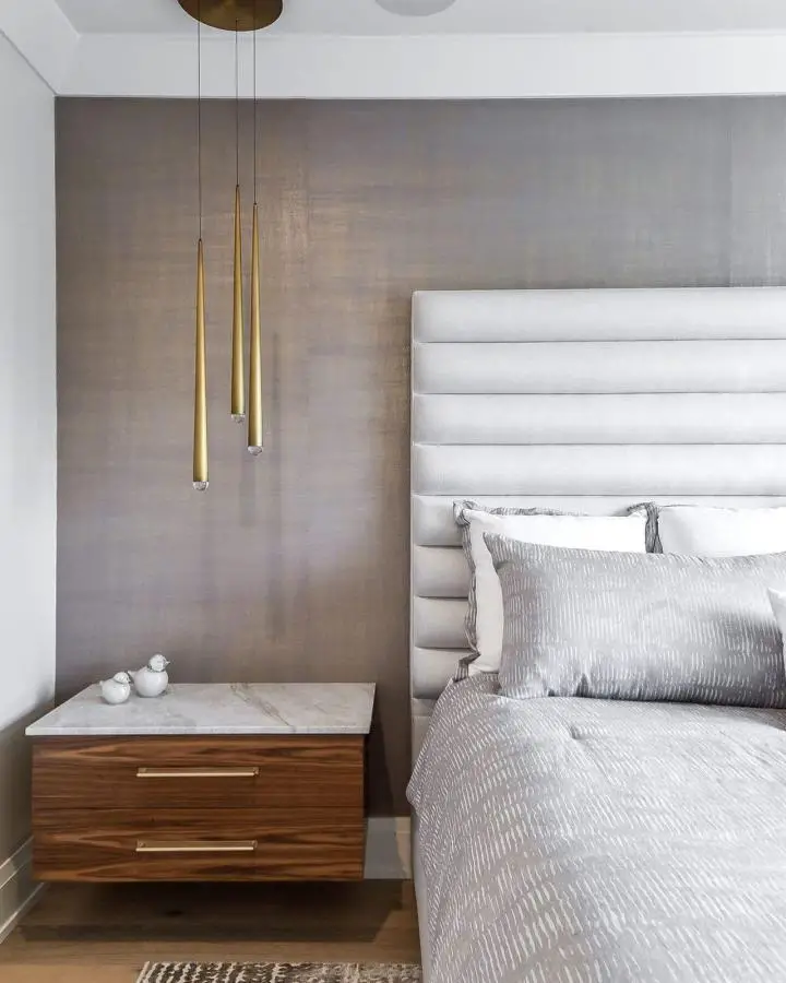 Modern pendant lights with luxurious master bedroom ideas from @darlgrootersltd. Brass fixtures hang above floating walnut nightstand.