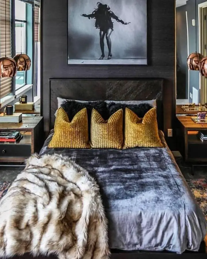 Moody bedroom with golden velvet pillows from @lovehappensbyanna. Dark marble headboard and faux fur throw create textural contrast.