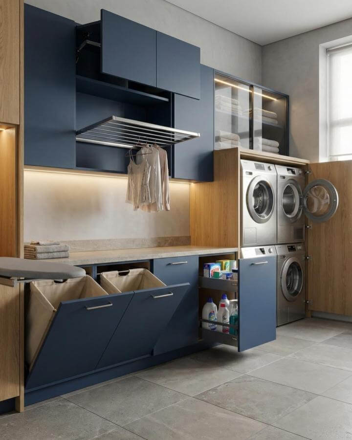 Navy matte cabinets with hidden hampers and warm wood accents create luxury laundry room ideas by @madrin.ae in a modern space.