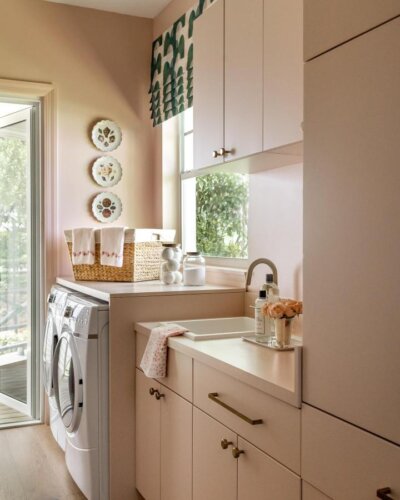 Soft warm neutral laundry room with brass hardware and patterned shade from @shani_core_interiors_ showcasing luxury laundry room ideas in a bright space.