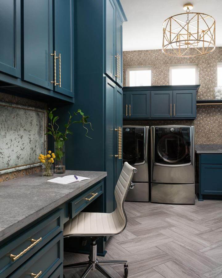 Deep blue cabinetry with brass handles and quartz countertop in a luxury laundry room by @nikolestarrinteriors designed for style and function.