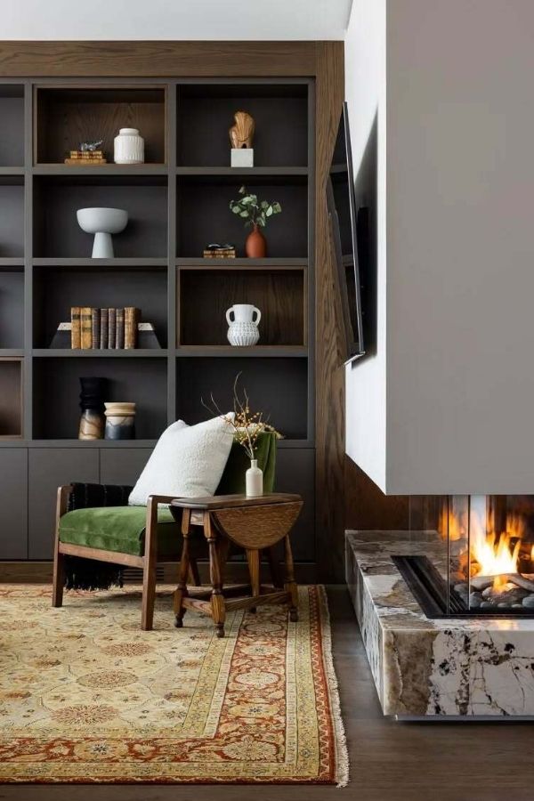 Warm fireplace with bookshelves, rich wood, inviting and elegant ambiance.