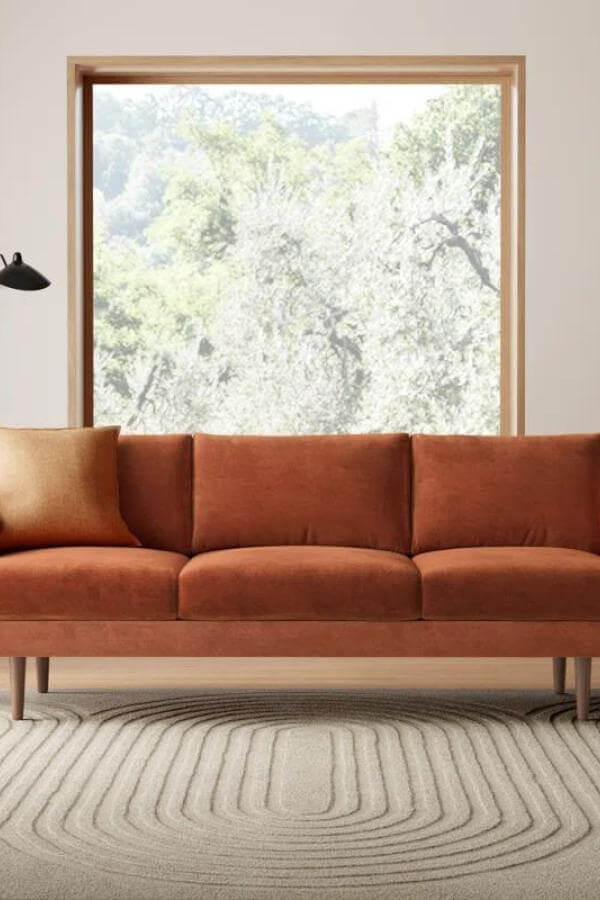 Earthy tone sofa from @designmomdiaries, enhancing warmth and texture in a mid-century inspired living room.